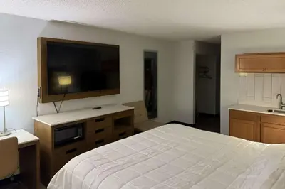 a bedroom with a bed and a flat screen tv at Suburban Studios Fairborn - Dayton in Fairborn