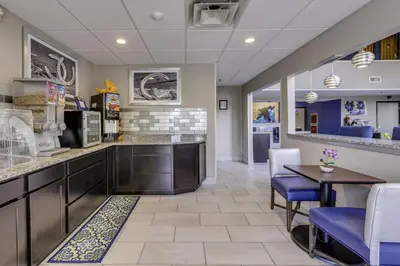 a lobby with a dining area with a table and chairs at Guesthouse Inn & Suites Lexington in Lexington