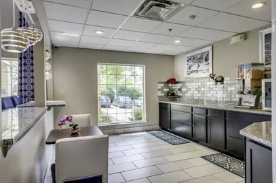 a large kitchen with a counter and a table at Guesthouse Inn & Suites Lexington in Lexington