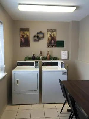 a kitchen with twowashes and a table with aperature at Guesthouse Inn & Suites Lexington in Lexington