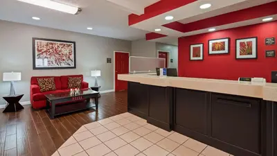 a waiting room with a red wall and a red couch at Best Western Paris Inn in Paris