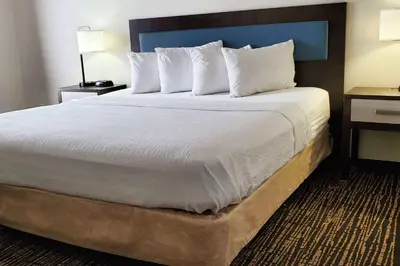 a bedroom with a large bed with white sheets and pillows at Wingate by Wyndham Canton-Hall of Fame in Canton