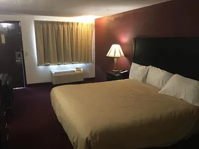a hotel room with a large bed and a window at Super 9 Motel Troy in Troy