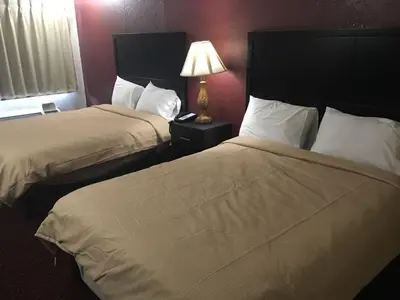 a hotel room with two beds and a lamp at Super 9 Motel Troy in Troy