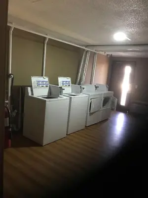 a laundry room with several washers and dryers at Super 9 Motel Troy in Troy