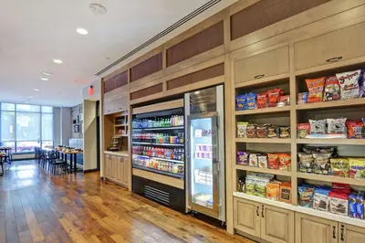a room with a refrigerator and shelves with food at The Cincinnatian Curio Collection by Hilton in Cincinnati