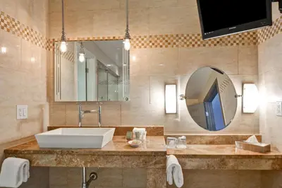 a bathroom with a sink and a mirror at The Cincinnatian Curio Collection by Hilton in Cincinnati