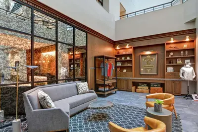 a living room with a couch and a large window at The Cincinnatian Curio Collection by Hilton in Cincinnati