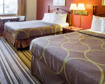 a hotel room with two beds and a table at Rodeway Inn Florence - Cincinnati South in Florence