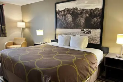 a hotel room with a bed and a painting on the wall at Super 8 by Wyndham Gas City Marion Area in Gas City