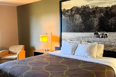 a bedroom with a bed with a painting on the wall at Super 8 by Wyndham Gas City Marion Area in Gas City