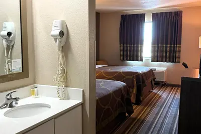 a hotel room with a bed and a sink at Super 8 by Wyndham Gas City Marion Area in Gas City