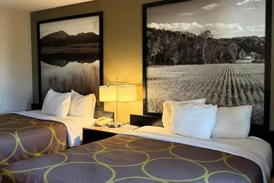 two beds in a hotel room with a picture on the wall at Super 8 by Wyndham Gas City Marion Area in Gas City