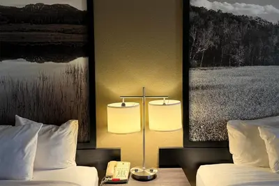 a hotel room with two beds and a lamp with a phone at Super 8 by Wyndham Gas City Marion Area in Gas City