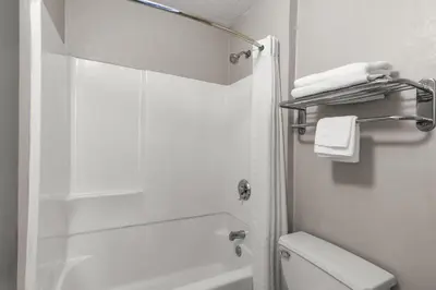 a white bathroom with a shower and a toilet at Days Inn by Wyndham Charleston WV in Charleston