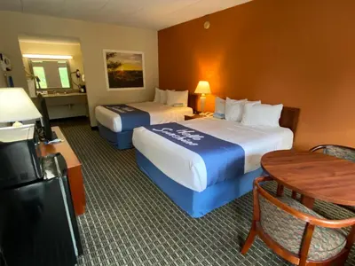a hotel room with two beds and a table at Days Inn by Wyndham Morehead in Morehead