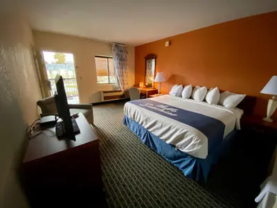 a hotel room with a bed and a flat screen tv at Days Inn by Wyndham Morehead in Morehead