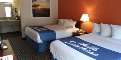 a hotel room with two beds and a desk at Days Inn by Wyndham Morehead in Morehead