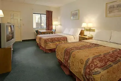 a hotel room with two beds and a flat screen tv at Days Inn by Wyndham Morehead in Morehead