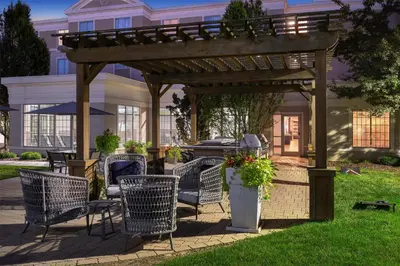 a wooden pergola with chairs and tables in a yard at Homewood Suites by Hilton Columbus/Polaris in Columbus