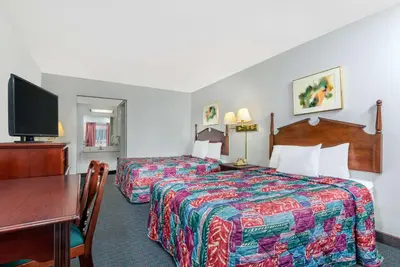 a hotel room with two beds and a desk at Days Inn by Wyndham Mt. Sterling in Mount Sterling