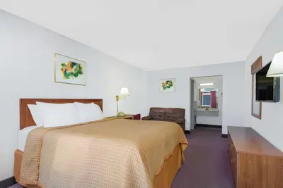a hotel room with a bed and a television at Days Inn by Wyndham Mt. Sterling in Mount Sterling