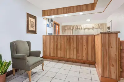 a waiting room with a chair and a wooden wall at Days Inn by Wyndham Mt. Sterling in Mount Sterling