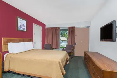 a hotel room with a bed and a flat screen tv at Days Inn by Wyndham Mt. Sterling in Mount Sterling