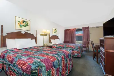 a hotel room with two beds and a television at Days Inn by Wyndham Mt. Sterling in Mount Sterling