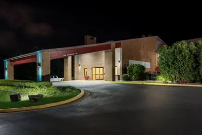 a large brick building with a road in front of it at Red Roof Inn & Suites Lexington - Hamburg in Lexington