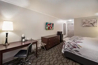 a hotel room with a desk and a bed and a desk at Red Roof Inn & Suites Lexington - Hamburg in Lexington