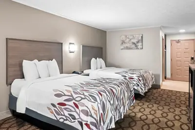 a hotel room with two beds and a door at Red Roof Inn & Suites Lexington - Hamburg in Lexington