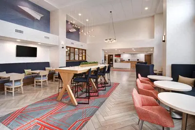 a dining room with tables and chairs and a tv at Hampton Inn & Suites Dayton-Vandalia in Murlin Heights