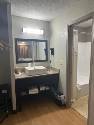 a bathroom with a sink and a mirror and a tub at Red Roof Inn Anderson, IN in Anderson