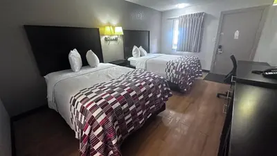 a hotel room with two beds and a desk at Red Roof Inn Anderson, IN in Anderson