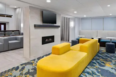 a lobby with a yellow couch and a fireplace at Hampton Inn & Suites Cleveland-Beachwood in Beachwood