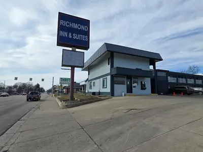 a building with a sign for amanentmanent inn and suites at Richmond Inn and Suites in Richmond