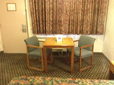 a room with a table and two chairs and a window at Richmond Inn and Suites in Richmond