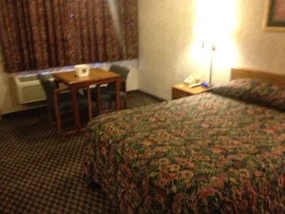 a hotel room with a bed and a table and a desk at Richmond Inn and Suites in Richmond
