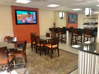 a dining room with tables and chairs and a flat screen tv at Ramada Limited - Mount Sterling in Mount Sterling