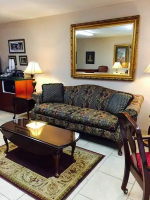 a living room with a couch and a table and a mirror at Brookshire Inn in Inez