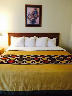 a bed in a hotel room with a colorful bedspread at Brookshire Inn in Inez