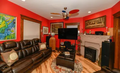 a living room with a leather couch and a fireplace at Berrodin Bed & Breakfast in Akron