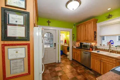 a kitchen with green walls and wooden cabinets at Berrodin Bed & Breakfast in Akron