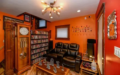 a living room with a leather chair and a clock at Berrodin Bed & Breakfast in Akron