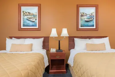 a hotel room with two beds and two lamps at Ramada by Wyndham Catlettsburg Ashland in Catlettsburg