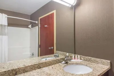 a bathroom with a sink and a mirror at Ramada by Wyndham Catlettsburg Ashland in Catlettsburg