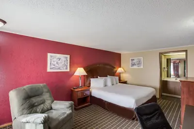 a hotel room with a bed and a chair at Knights Inn Ashland in Ashland