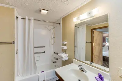 a bathroom with a sink and a shower and a mirror at Knights Inn Ashland in Ashland