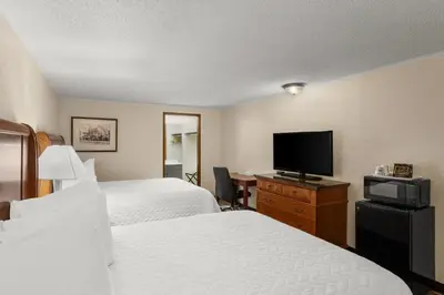 a hotel room with two beds and a flat screen tv at Knights Inn Ashland in Ashland